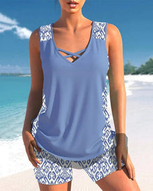 Sculpting two-piece tankini in light blue with a v-neckline, featuring patterned sides and matching shorts, perfect for summer.