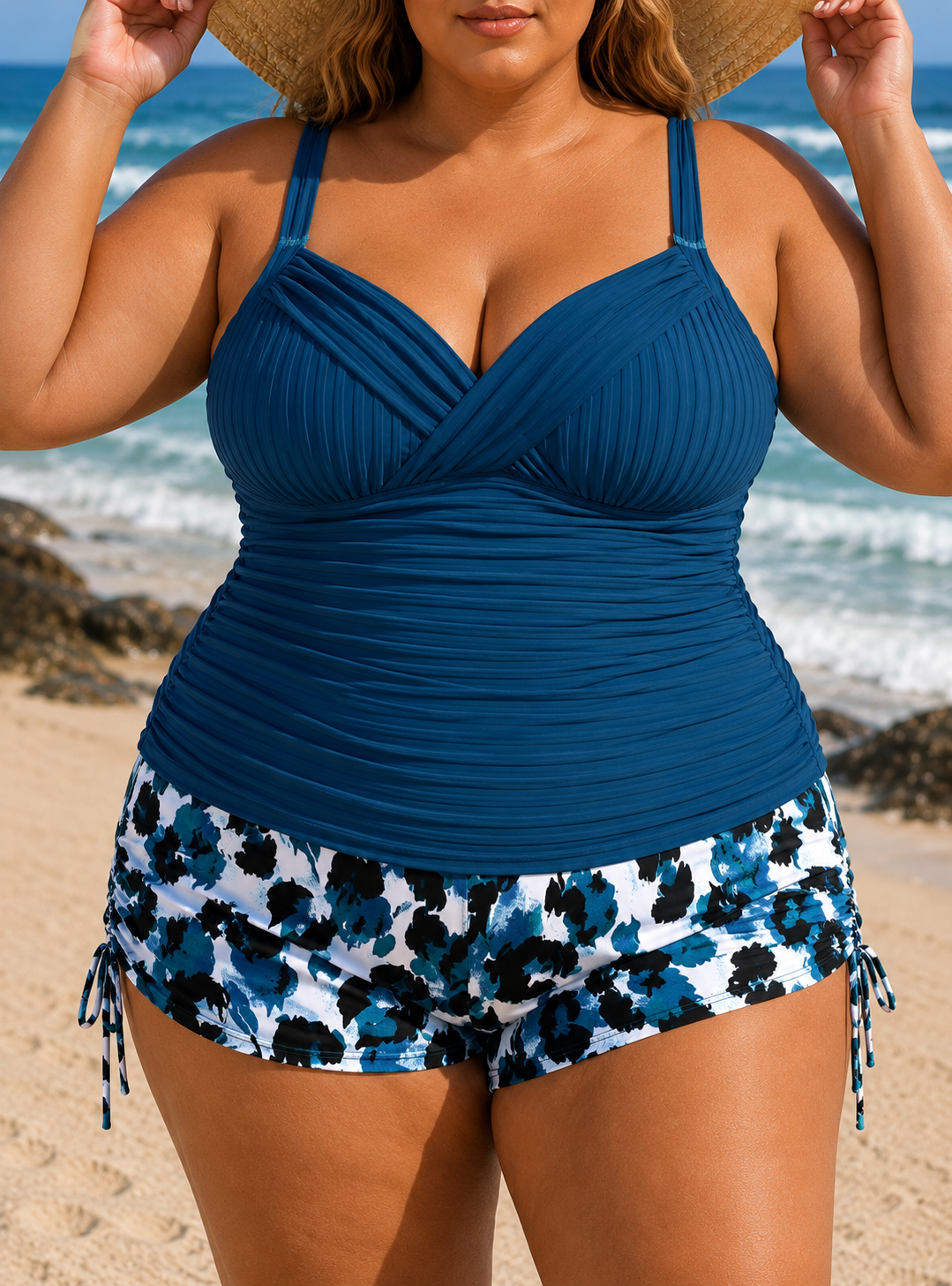 Ribbed navy tankini with a scooped neckline paired with white and blue floral printed shorts, model holding a sunhat.