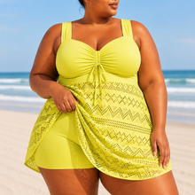 Flowing overlay swim dress in vibrant yellow, featuring a structured top and chevron patterned skirt overlay.