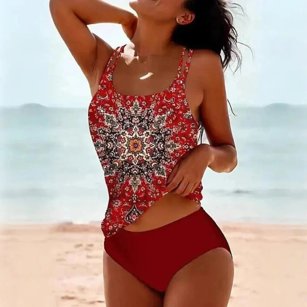 Two-piece printed tankini in red features a U-neck top with a vibrant pattern and high-waisted solid bottoms.