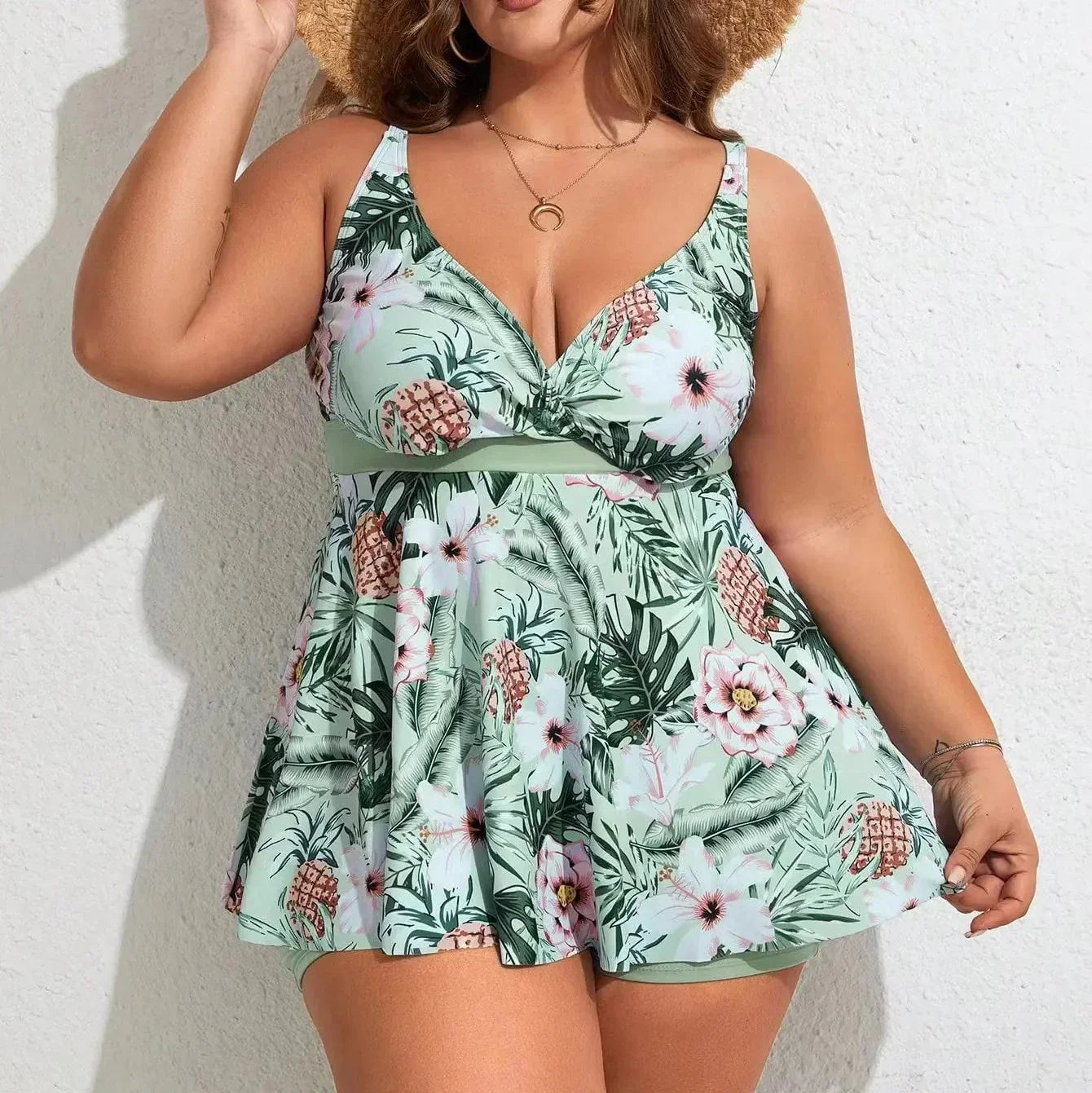 Tropical floral swim dress in mint green with a V-neckline, broad straps, and built-in boyshorts for coverage.