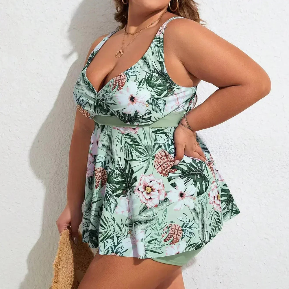 Tropical floral swim dress in pastel green with built-in boyshorts, V-neckline, and flowing skirt.
