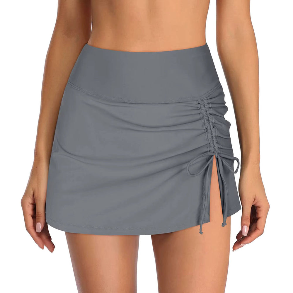 Gray swim shorts with a wide waistband, drawstring, side slit, and ruched detailing on one side, styled for beach wear.