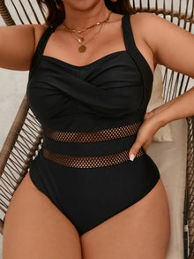Black one-piece swimsuit featuring a flattering V-neckline and sheer paneled detailing, styled for a relaxed look.