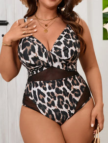 One-piece swimsuit featuring a paneled V-neck design in a black and beige leopard print, paired with layered gold necklaces.